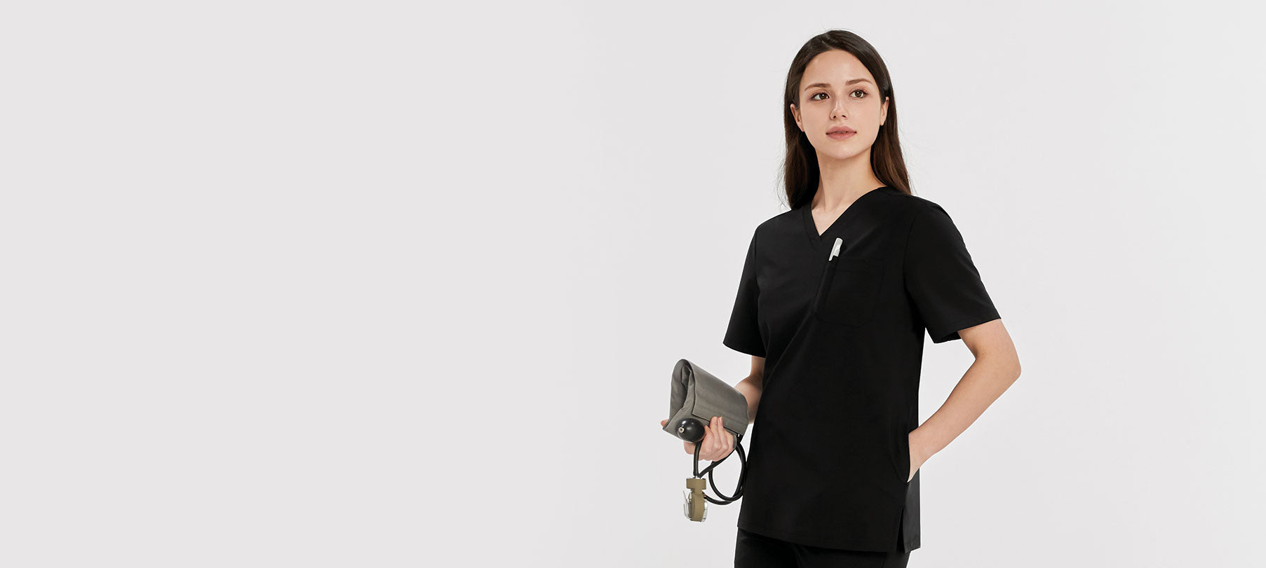 a nurse wearing black scrubs standing with her arms on her waist.