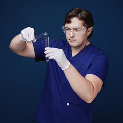 Image of Man in admiral blue scrubs conducting a lab experiment, wearing safety goggles and gloves while handling test tubes,Admiral Blue