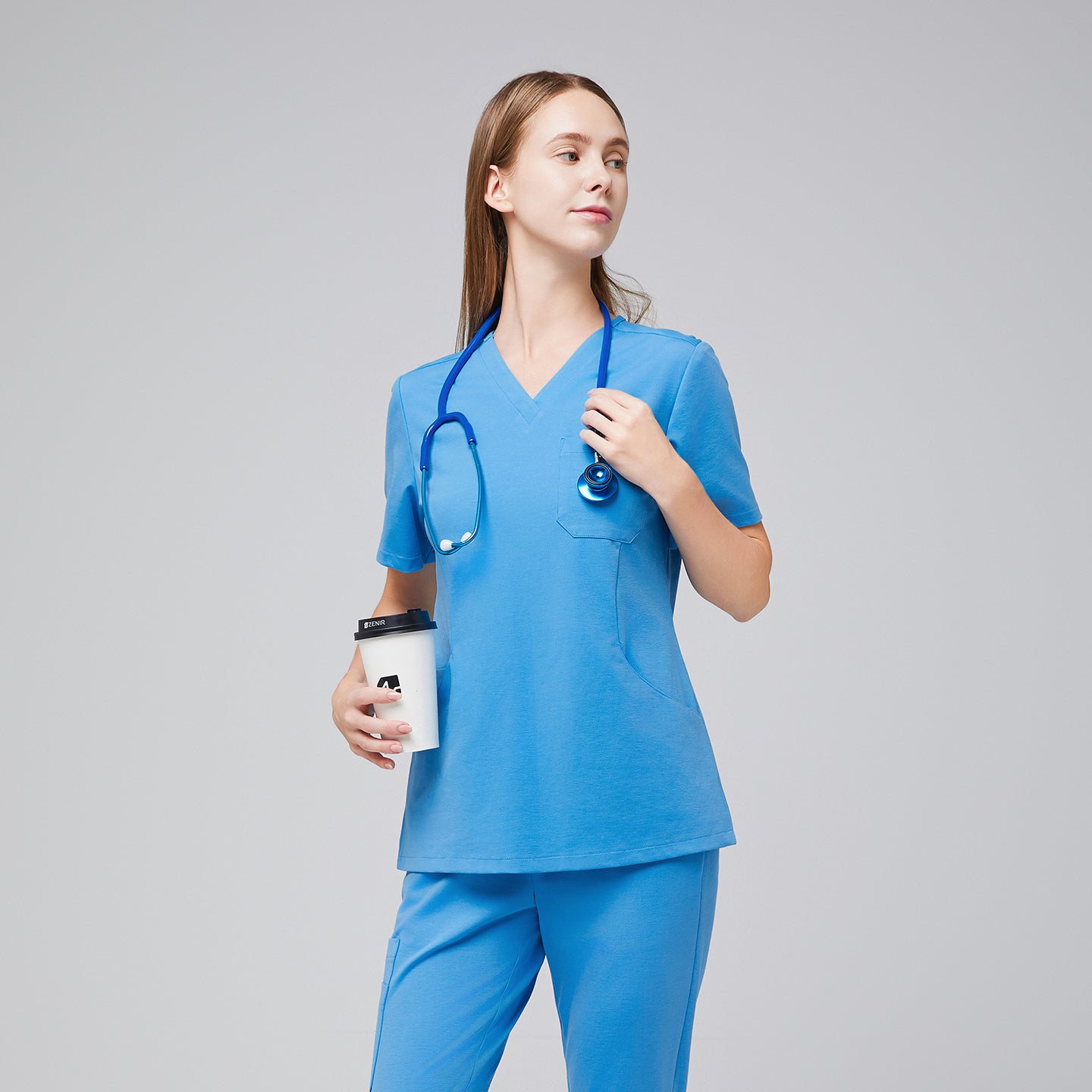 Woman in an aqua blue scrub set holding a coffee cup, with a stethoscope around her neck, looking confidently to the side.,Aqua Blue