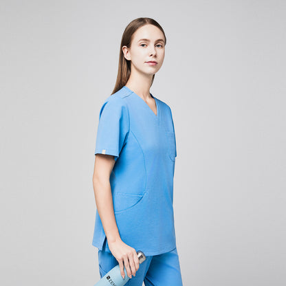 Female model in aqua blue soft stretch scrub top and pants, holding a branded water bottle, shown in a half-side view,Aqua Blue