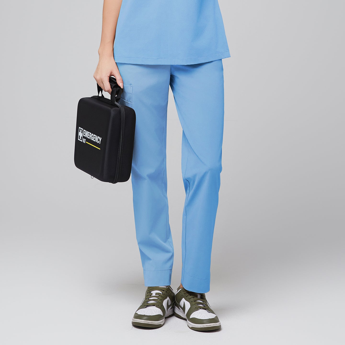 Female wearing light blue scrub pants, holding a black emergency kit, paired with green and white sneakers,Aqua Blue