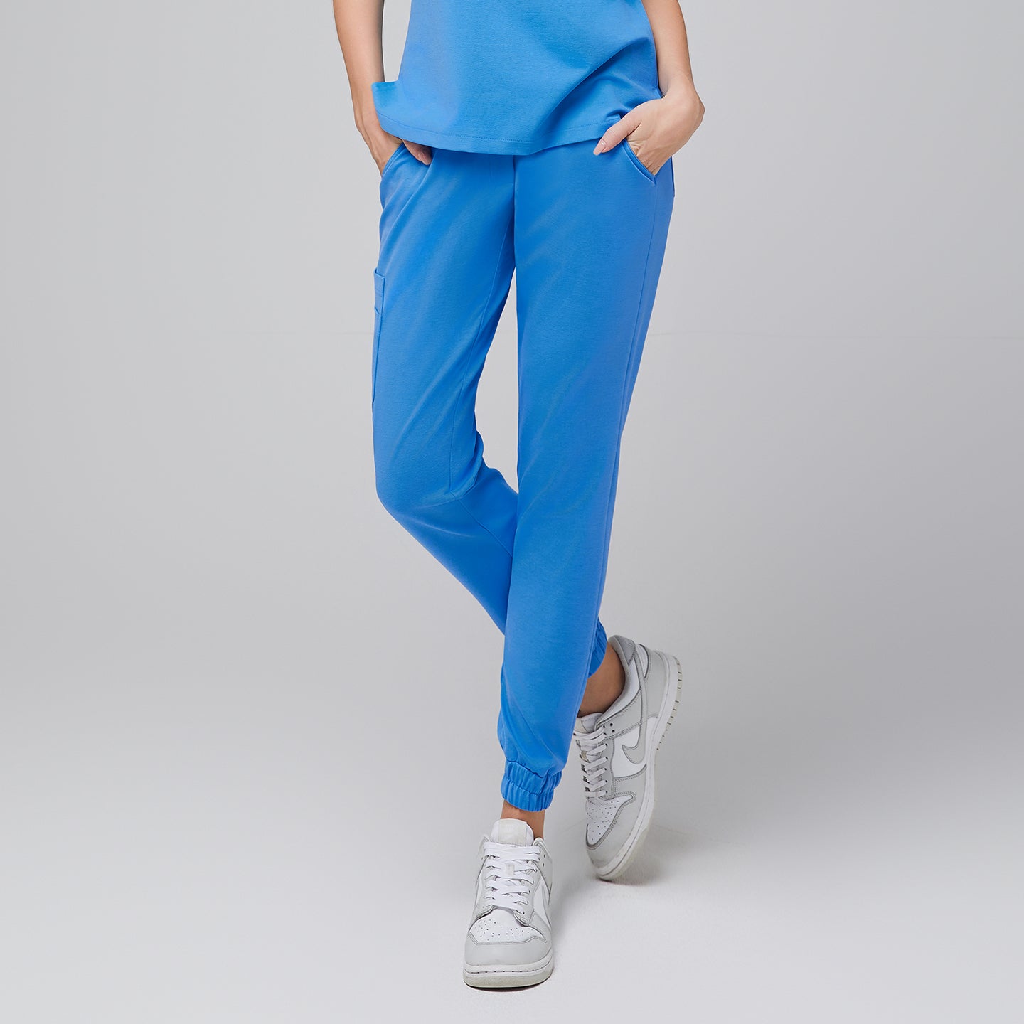 Close-up of aqua blue jogger scrub pants with side pockets, paired with white sneakers,Aqua Blue