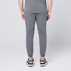 Image of Back view of ash gray jogger scrub pants with elastic cuffs and back pockets, styled with black and white sneakers,Ash Gray