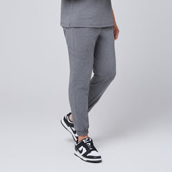 Image of Ash gray jogger scrub pants with side pocket and elastic cuffs, paired with black and white sneakers,Ash Gray