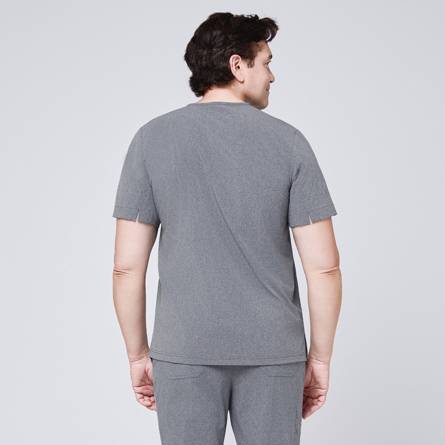 Back view of a male model wearing an ash gray scrub set with short sleeves and clean stitching details,Ash Gray