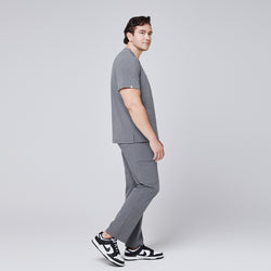 Image of Male model in side profile wearing an ash gray scrub set with black and white sneakers, showcasing clean lines and functional design,Ash Gray