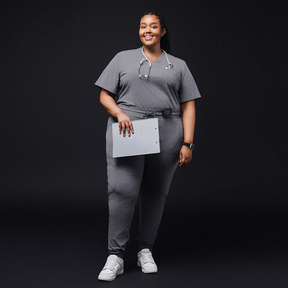 Healthcare worker in ash gray scrub top and pants holding a folder and wearing a stethoscope, full body view,Ash Gray