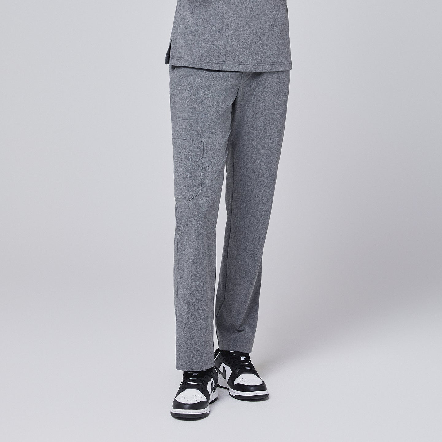 Ash gray straight-leg scrub pants with a split hem, featuring a cargo pocket, paired with black-and-white sneakers on a neutral background,Ash Gray