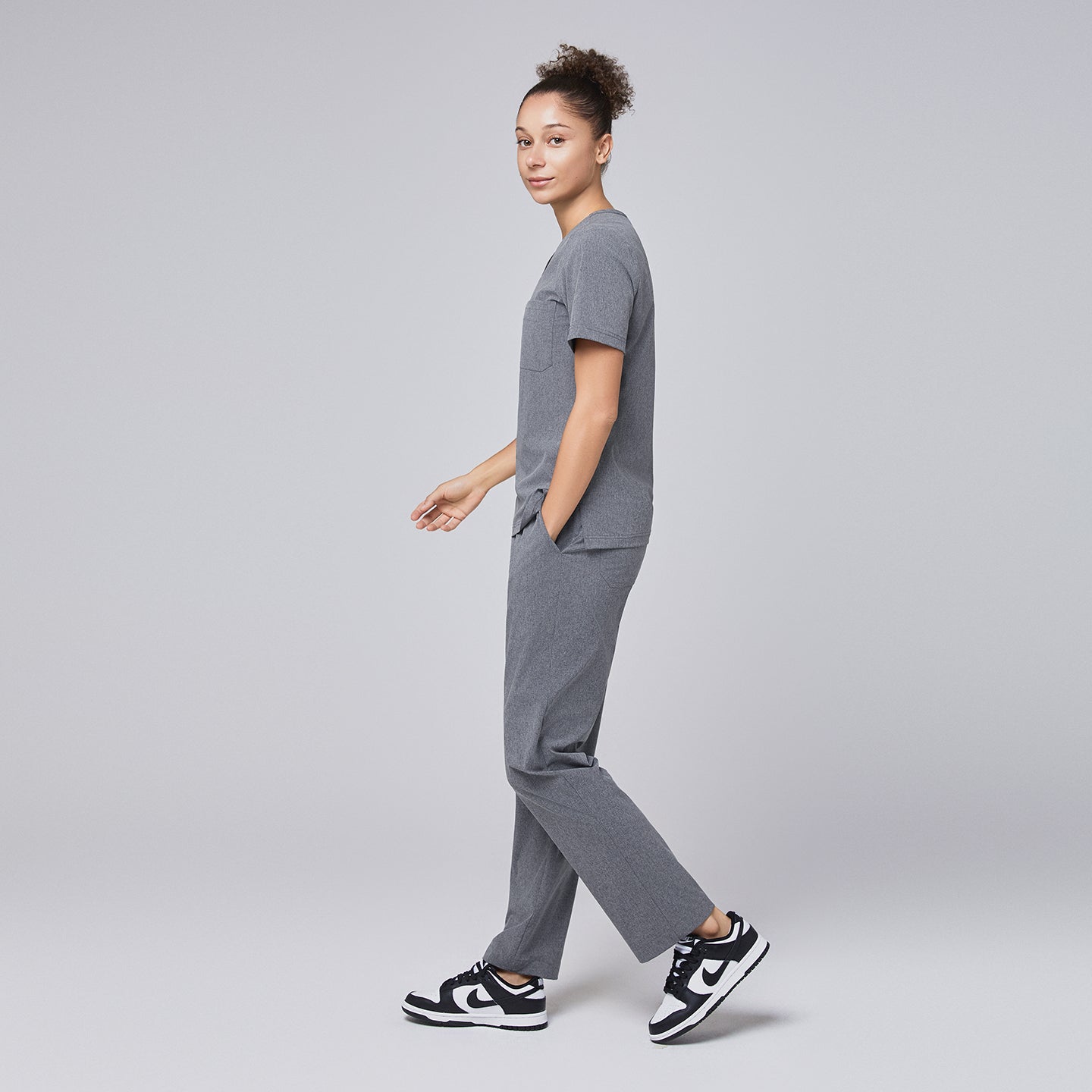 Ash gray straight-leg scrub pants with a split hem, featuring a cargo pocket, paired with black-and-white sneakers on a neutral background,Ash Gray