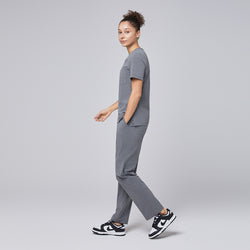 Image of Ash gray straight-leg scrub pants with a split hem, featuring a cargo pocket, paired with black-and-white sneakers on a neutral background,Ash Gray