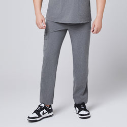 Image of Male model wearing ash gray relaxed-fit scrub pants with side pockets, paired with black and white sneakers, presenting a comfortable and professional medical look,Ash Gray