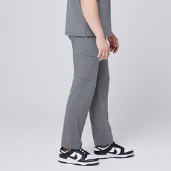 Image of Male model wearing ash gray relaxed-fit scrub pants with side pockets, styled with black and white sneakers, showcasing a side angle for a modern and functional look,Ash Gray