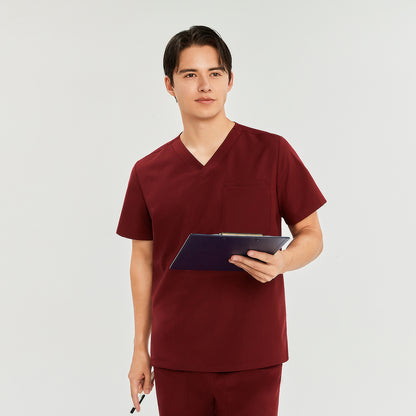 Male model wearing a scrub top with a chest pocket, paired with matching scrub pants, holding a clipboard and pen, looking to the side,Burgundy