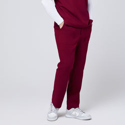 Image of Side view of burgundy 8-pocket straight scrub pants with functional pockets, paired with white sneakers,Burgundy