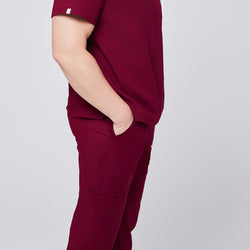 Image of Side profile of burgundy scrub pants with functional pockets and matching scrub top, showcasing a clean and professional design,Burgundy