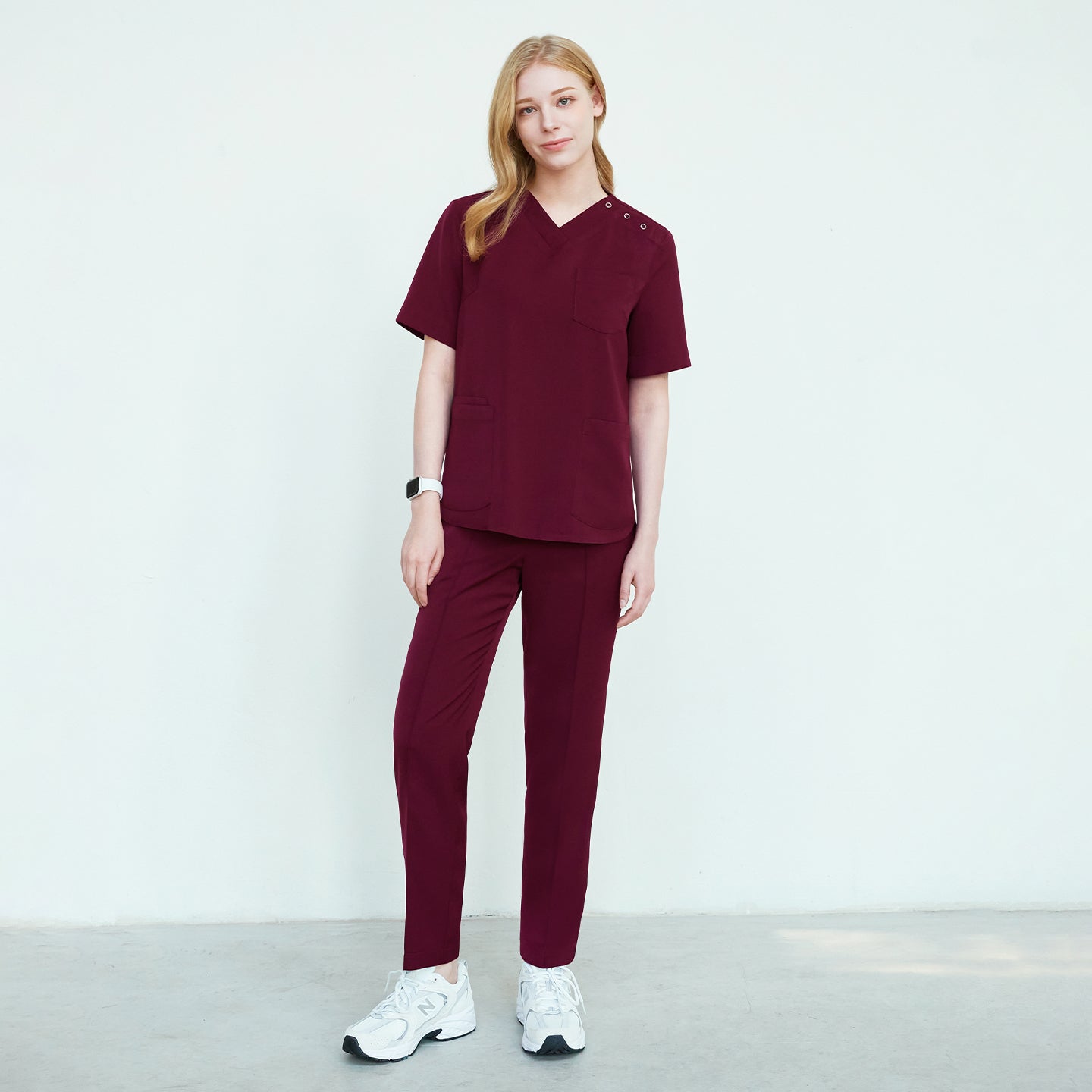 Burgundy Line Banding Scrub Pants, full-body view, featuring a matching V-neck scrub top with front pockets and button details, paired with white sneakers,Burgundy