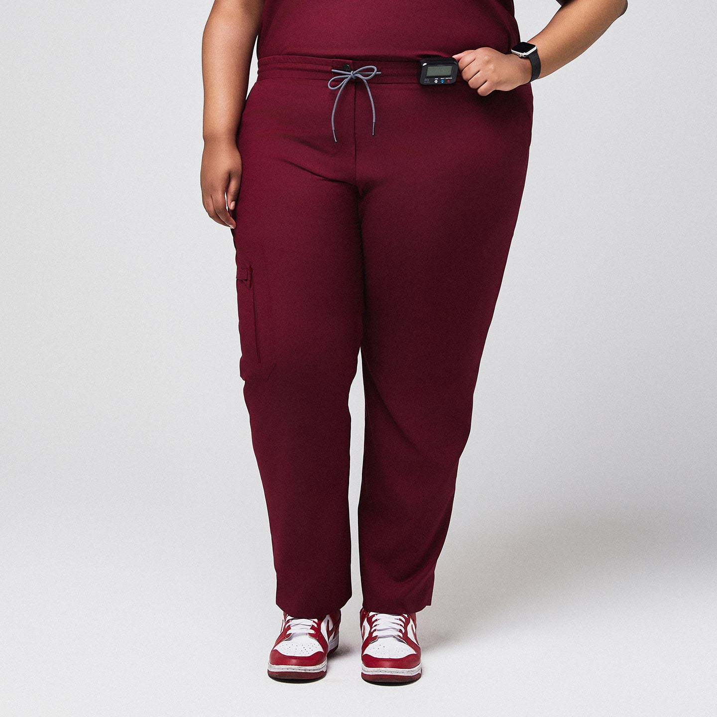 Burgundy scrub pants with zipper pocket and split hem, paired with red sneakers,Burgundy