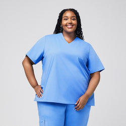 Image of Plus-size model wearing a light blue 3-pocket scrub top and matching pants, offering a comfortable and practical outfit for healthcare professionals,Ceil Blue