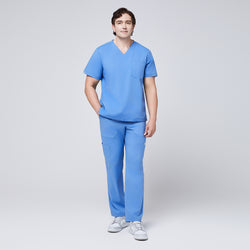 Image of Male model wearing a ceil blue V-neck scrub set with a three-pocket top and straight-leg pants, paired with white sneakers for a clean, professional look,Ceil Blue