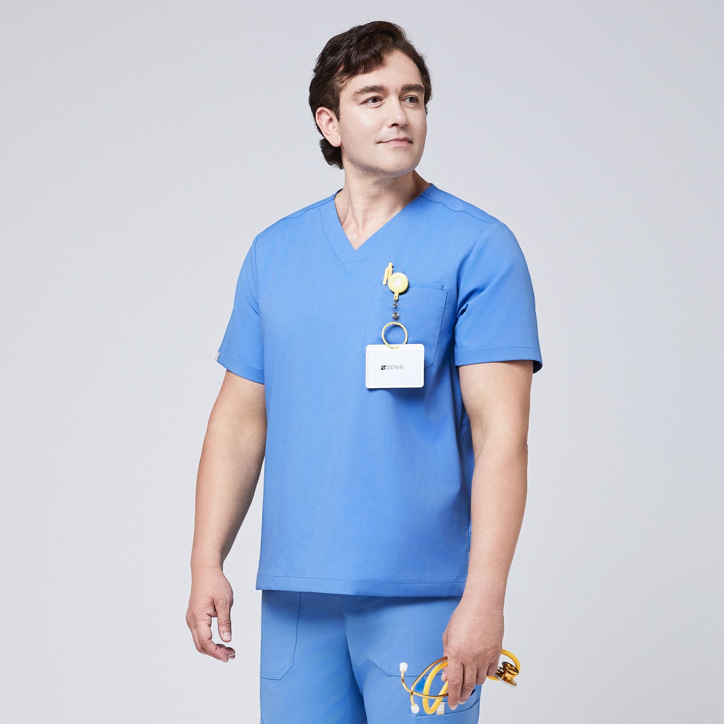 Male model wearing a ceil blue V-neck scrub set with a chest pocket, holding a yellow stethoscope, and an ID badge clipped to the top, showcasing a professional medical uniform,Ceil Blue