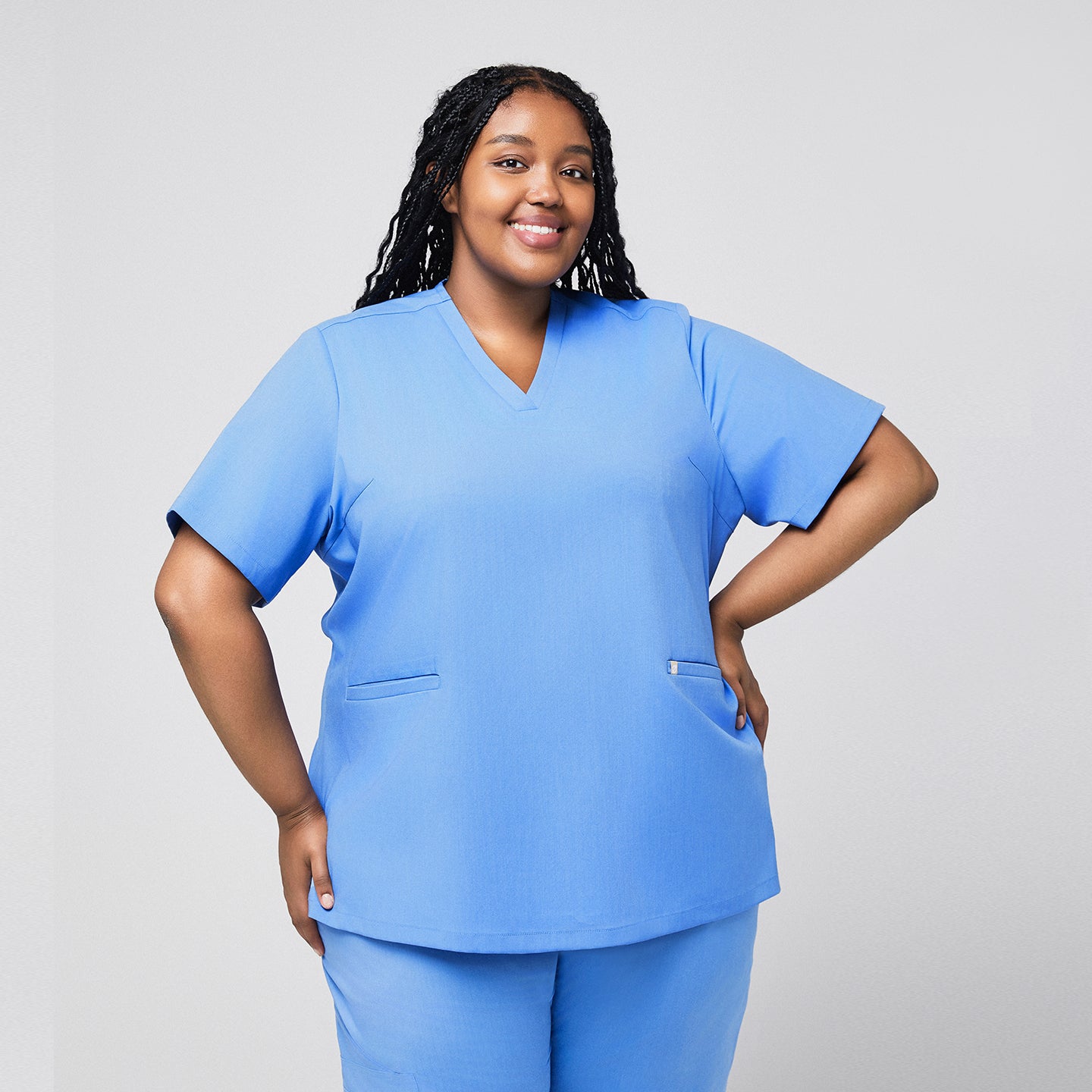 Plus-size healthcare professional in a ceil blue scrub top with hands on hips, showing a confident front view,Ceil Blue