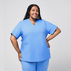 Image of A plus-size model wearing a Ceil Blue Double Pocket Scrub Top, smiling with hands on her hips,Ceil Blue