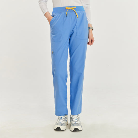  Front view of a woman wearing ceil blue zipper slit scrub pants with a yellow drawstring and hands in pockets,Ceil Blue