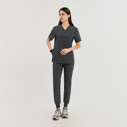 Female model in charcoal gray 3-pocket scrub top and jogger-style pants, providing a comfortable and functional uniform for healthcare professionals,Charcoal Gray