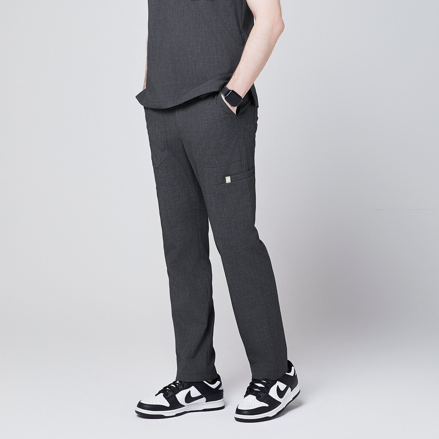 man side view, wearing Zenir charcoal-gray zipper straight scrub pants paired with black-and-white sneakers and a smartwatch,Charcoal Gray