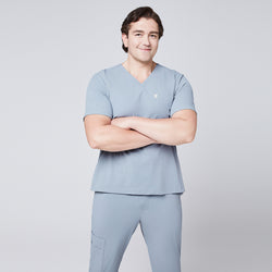 Image of Man wearing a cool gray scrub set with arms crossed, featuring a single-pocket V-neck top,Cool Gray