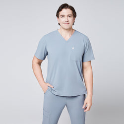 Image of A man wearing a Cool Gray Single Pocket Scrub Top and Cool Gray StretchFit Jogger Scrub Pants, standing in a relaxed pose,Cool Gray