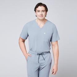 Image of Man wearing a cool gray scrub set with arms crossed, featuring a single-pocket V-neck top,Cool Gray