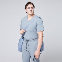 Image of Man in a cool gray scrub set, wearing protective glasses and carrying a matching shoulder bag and stethoscope,Cool Gray