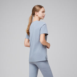 Image of Side-back view of a female healthcare professional in a cool gray scrub set, showing the clean design and relaxed fit,Cool Gray