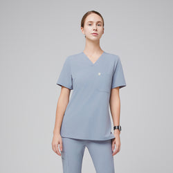 Image of Female healthcare professional wearing a cool gray V-neck scrub top and pants, standing with a confident posture,Cool Gray