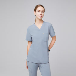 Image of Female healthcare professional wearing a cool gray scrub set with a single pocket, standing in a relaxed pose,Cool Gray