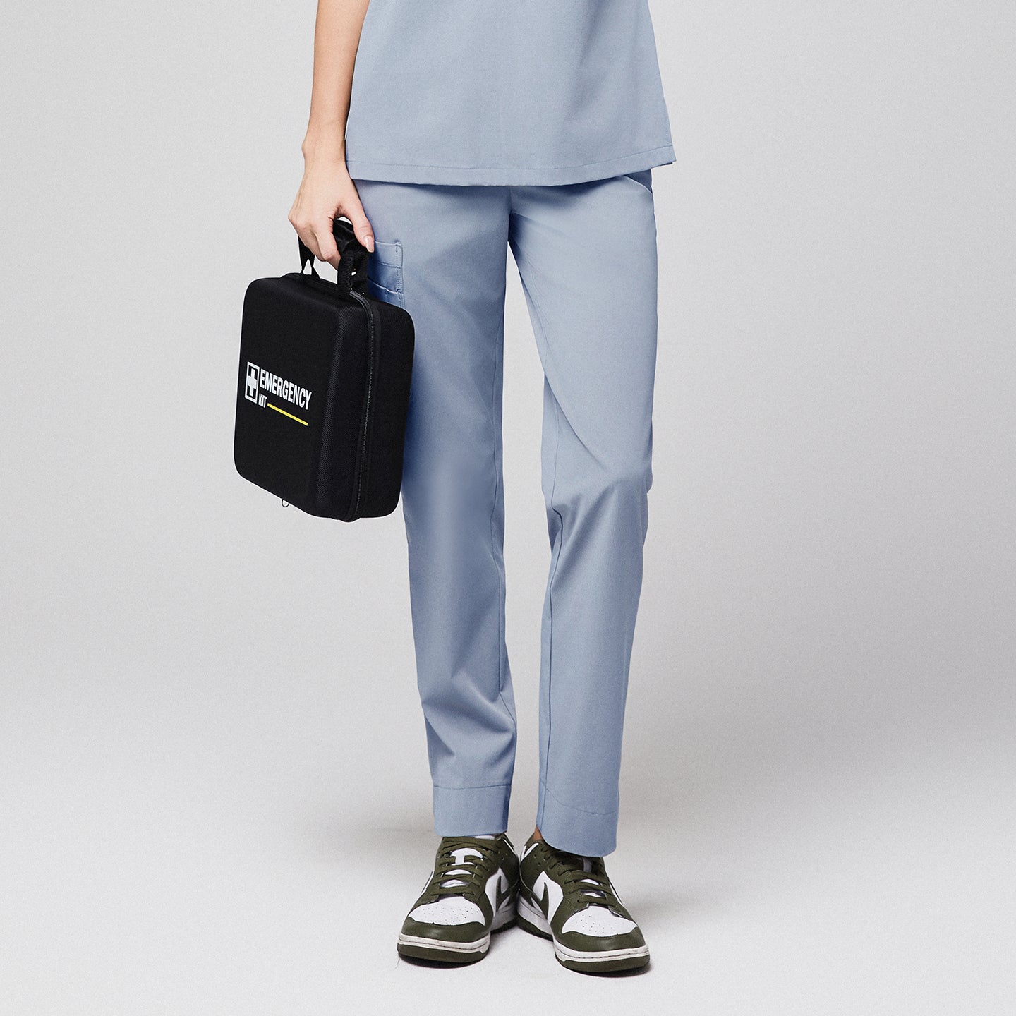 Healthcare professional in gray scrub pants holding an emergency kit,Cool Gray