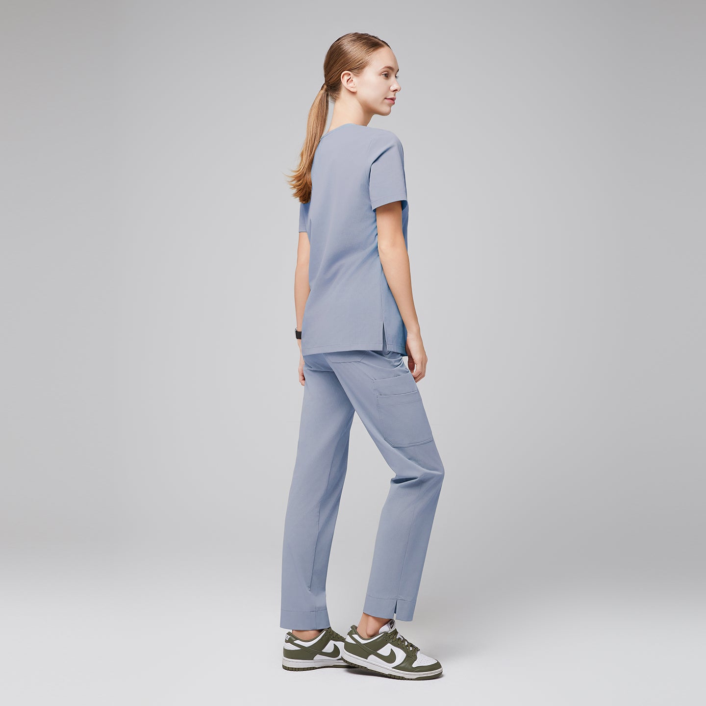 Model in cool gray scrubs, standing with back turned, wearing green and white sneakers,Cool Gray