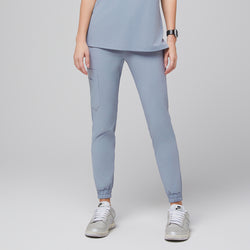 Image of Cool gray jogger scrub pants with elastic cuffs and a side cargo pocket, paired with silver and white Nike sneakers,Cool Gray