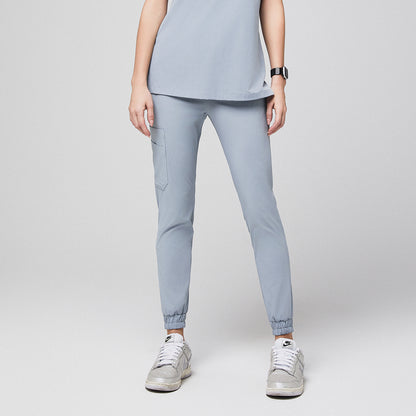 Medical professional wearing jogger-style scrub pants with side pocket and sneakers,Cool Gray