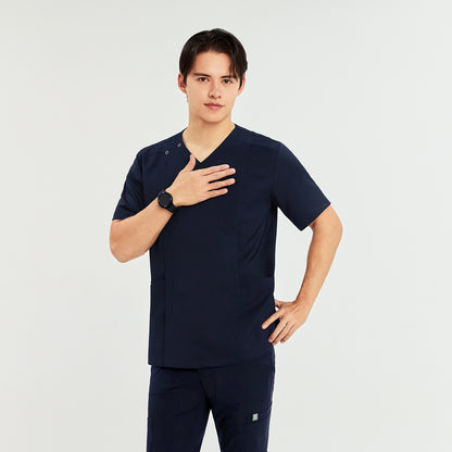 Man wearing a front zipper scrub top with chest and side pockets, matching straight-leg pants, one hand on chest and the other on hip,Navy