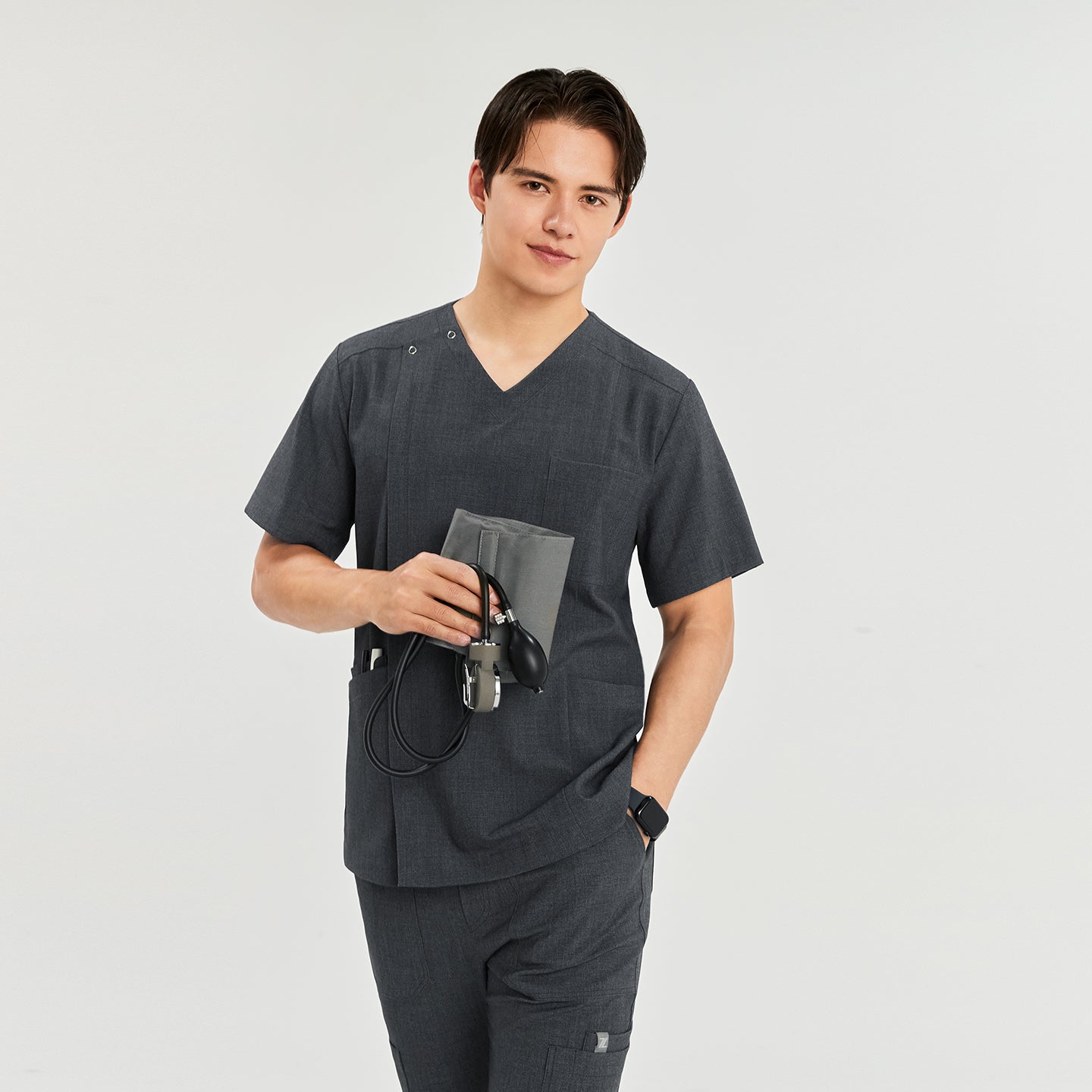 Man wearing a front zipper scrub top with matching cargo pants, holding a blood pressure monitor,Charcoal Gray