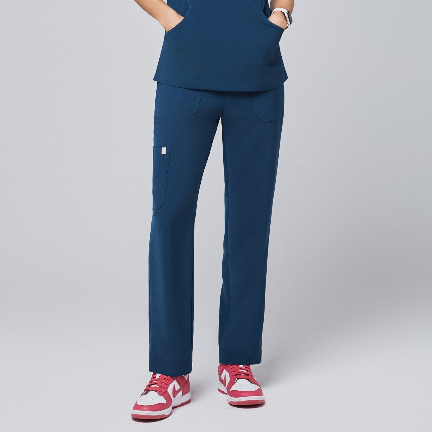 Model wearing the dark blue scrub pants, featuring a straight-leg design and functional pockets, paired with pink sneakers,Dark Blue