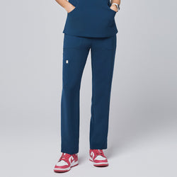 Image of Model wearing the dark blue scrub pants, featuring a straight-leg design and functional pockets, paired with pink sneakers,Dark Blue