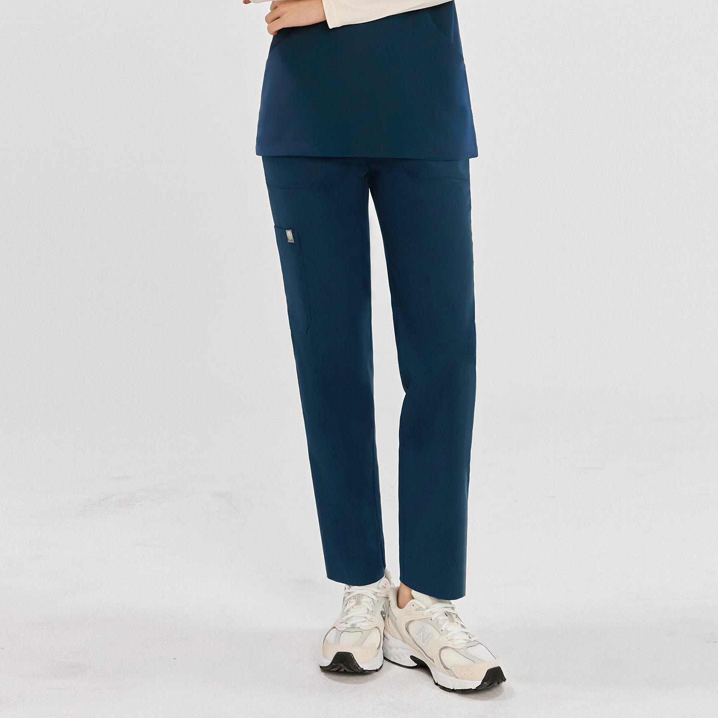 Woman wearing dark blue split hem scrub pants, showing the front view. Her arms are folded,Dark Blue