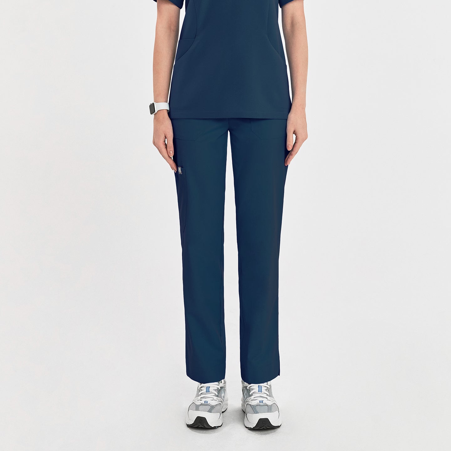 Woman wearing dark blue zipper slit scrub pants, shown from the front. Her hands are relaxed at her sides, showcasing the pants' straight-leg design,Dark Blue