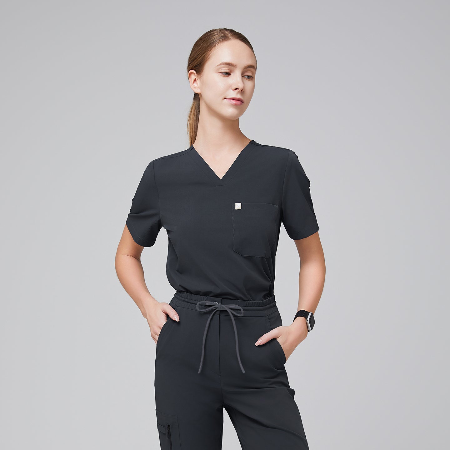 Half-side view of deep gray V-neck scrub top with a single chest pocket, paired with drawstring scrub pants for a sleek medical uniform,Deep Gray