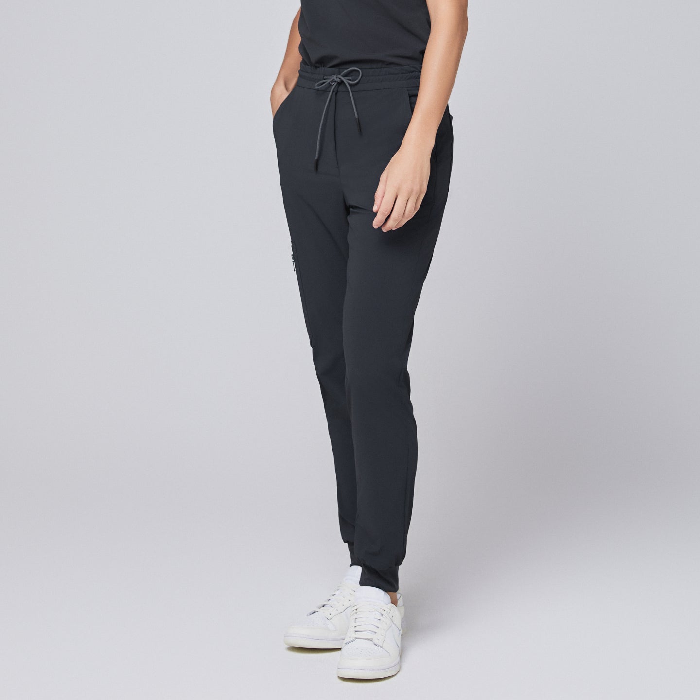 Deep gray jogger scrub pants with drawstring waistband and elastic cuffs, paired with white sneakers,Deep Gray