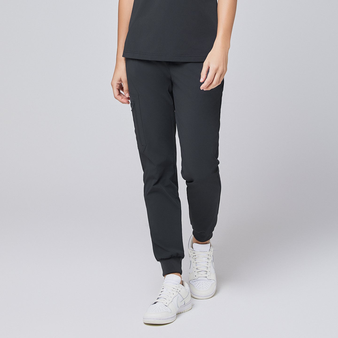 Deep gray jogger scrub pants with zipper pocket and elastic cuffs, paired with white sneakers,Deep Gray