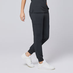 Image of Side view of deep gray jogger scrub pants with zipper pocket and elastic cuffs, styled with white sneakers,Deep Gray